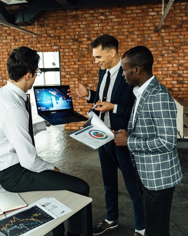 Colleagues collaborating on a laptop in a bright office