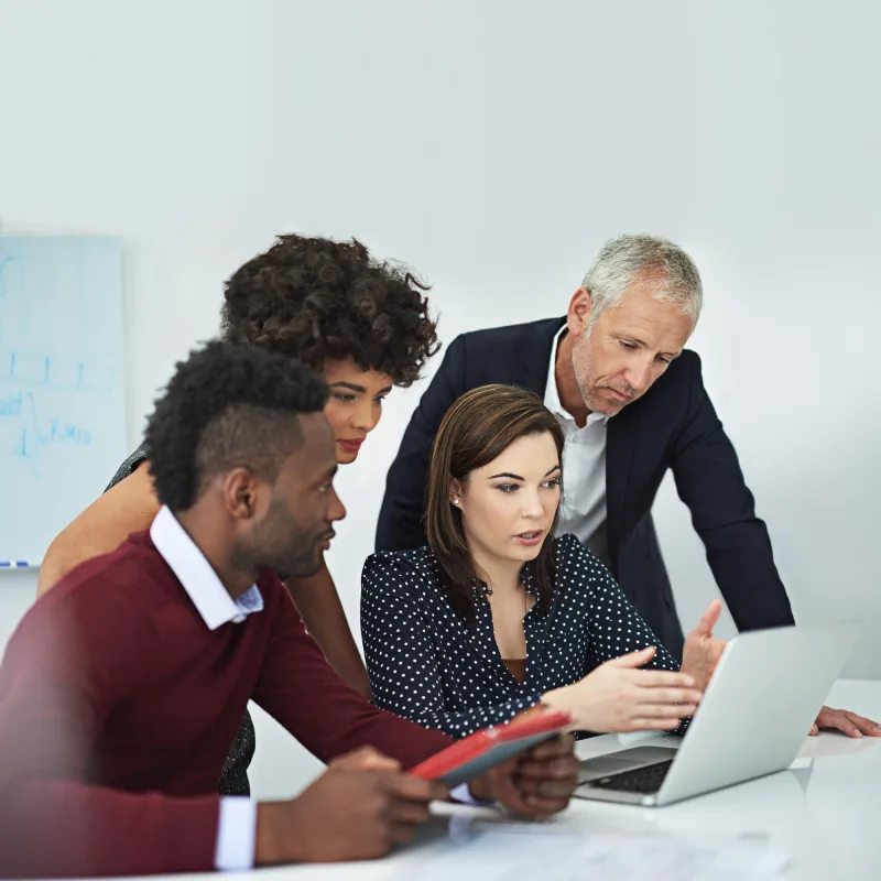 Director and colleagues planning a project on a laptop